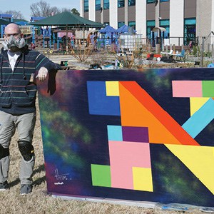 Hillel Smith with his mural for the ViBe District. Hillel Smith with his mural for the ViBe District.